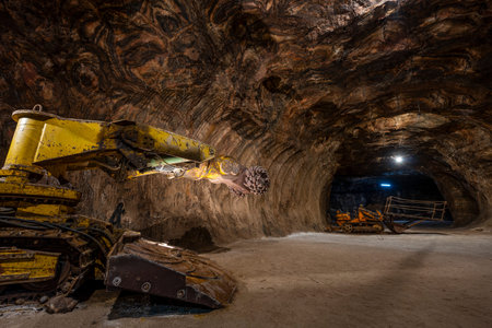 Tunnel boring machine operating inside an underground rocksalt mine in LoulÃ©, Algarve, showcasing heavy mining equipment, rugged mineral walls, and deep-earth excavation engineeringの写真素材