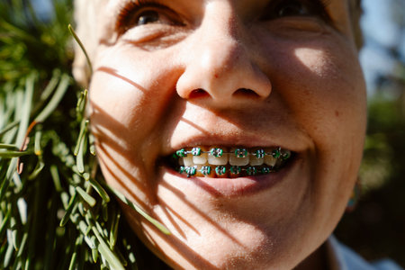 Portrait of a happy woman smiling with orthodontic braces while enjoying nature. Young adult female...