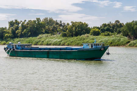 Barge on the Mekong. On the way to load new goods. The ship is high in the water because it is empty.の写真素材