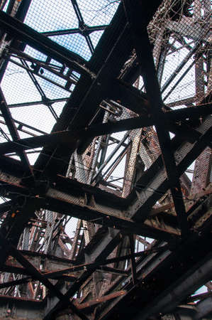 Detailed view of an old, no longer used railway bridge. It's old and very rusty.