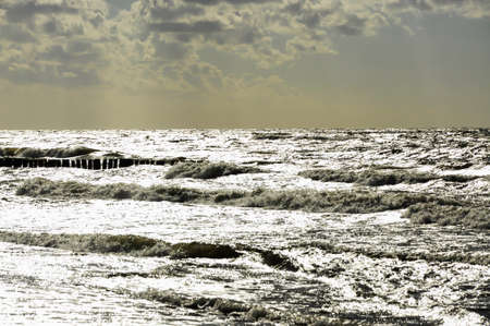 Evening mood by the sea near Kolberg in Poland. Dramatic sunset with clouds .. The water glistens in the setting sunの写真素材