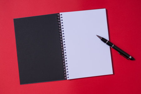 Open blank notebook with blue cover on red backgroun