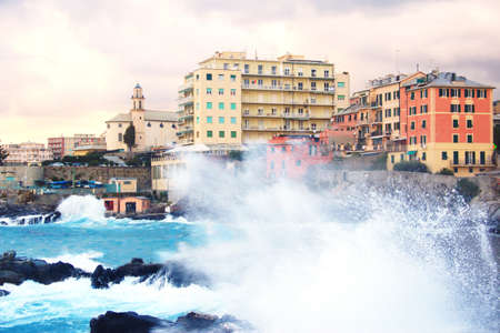 Genova Quinto with rough seas. View of the city of Genova Quinto Italy with wave in foreground.の写真素材