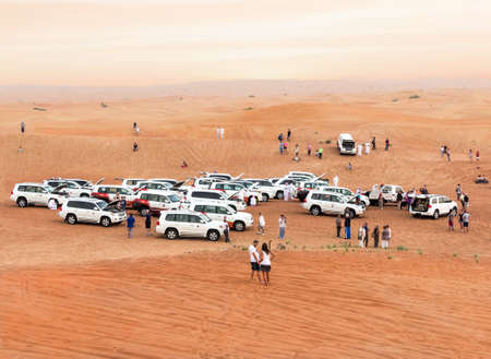 DUBAI, UNITED ARAB EMIRATES - 31 Ott, 2016: Crowd in the desert.Desert that surrounds the city of Dubai. Group of tourists make a safari with 4x4 car in the desert dunes.のeditorial素材
