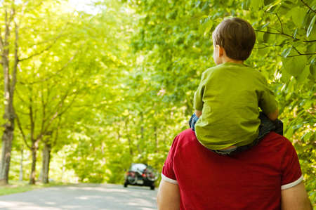 Father and son walking through park Father and son walking through park