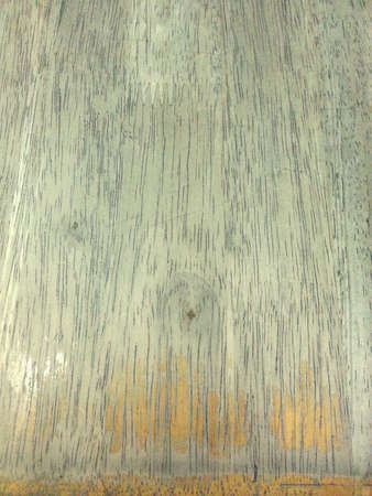 Close up photo of yellow brown dining table surface to show the texture.の素材