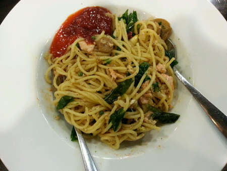 Tuna spaghetti stir fried ready to serve with tomato sauce on white dish.の素材