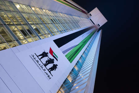 Abu Dhabu, UAE - 24 December, 2017: Huge Flag of UAE with Commemoration Day Picture on ADCB Headquarter Buildingのeditorial素材
