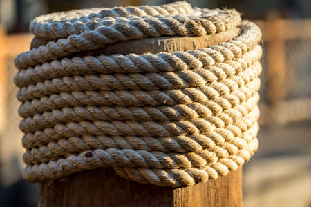 Close up of wrapped rope tied on wooden poleの写真素材