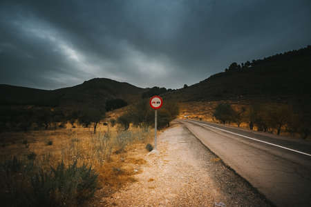 Mountain Road traffic sign indicating prohibition of overtaking on a curveの写真素材