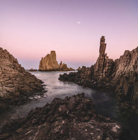Panoramic seascape at sunset of the reef of the mermaids, in Cabo de Gata, Almeria, Spain where you can see ancient volcanic lava chimneys of millions of years old in the Mediterranean seaの写真素材