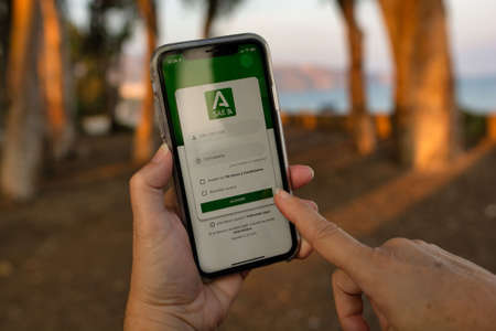 Aguadulce, Spain; October 2nd 2021: Woman's hands using her mobile phone. Trying to sign up at the employment office to look for a job through the SAE app of the Andalusian Employment Serviceのeditorial素材