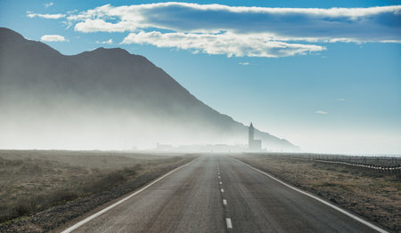 road leading to the silhouette of the church of las salinas de cabo de gata nijar with fog at dawn with a westerly windの写真素材
