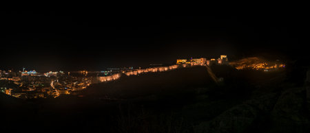 night view from the heights of the Alcazaba of the city of Almeria, the wall of Jayran, the Chanca, the old town and the port.の写真素材