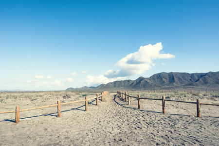 wooden fence in the desert with blue sky and white clouds backgroundの写真素材