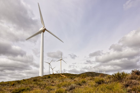Renewable energy wind turbines in the mountains with clouds in the skyの写真素材