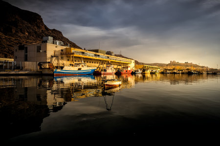 Fishing boats next to the fish market in the fishing port of Almeria on a cloudy day.の写真素材