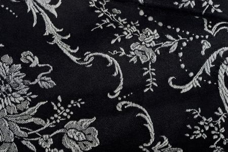 Piece of black material with white embroidery