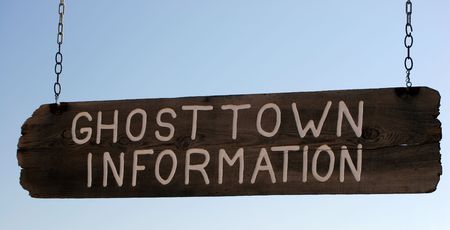 Sign hanging on Chains in Ghost Townの写真素材