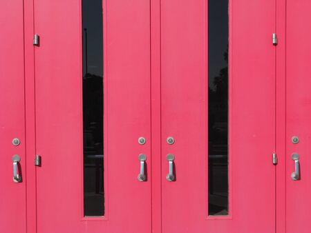 Bright pink entrance door with glass and wooden panelsの写真素材