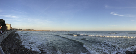 VENTURA, CA - APRIL 23, 2014  Walking people and surfers enjoying cool Pacific ocean breeze and waves near historic wooden pier, City of San Buenaventura, CAのeditorial素材