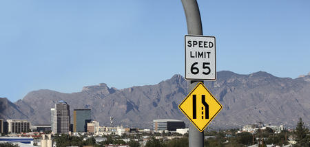 Approaching desert city of Tucson downtown with 65 miles per hour speed limit and narrow road ahead,...