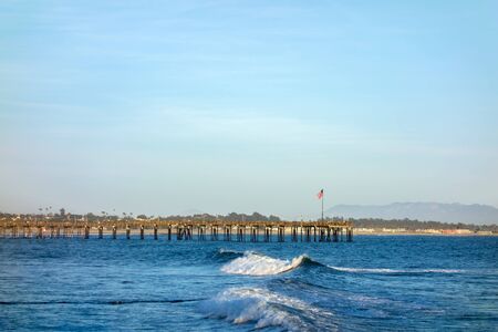 Surf waves near historic wooden pier in city of San Buena Ventura, Southern Californiaの写真素材