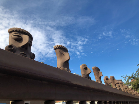 PHOENIX, AZ, USA - DECEMBER 8, 2017: Backyard fence of Phoenix Convention Center topped with row of head sculptures styled like Native American tribes art workのeditorial素材