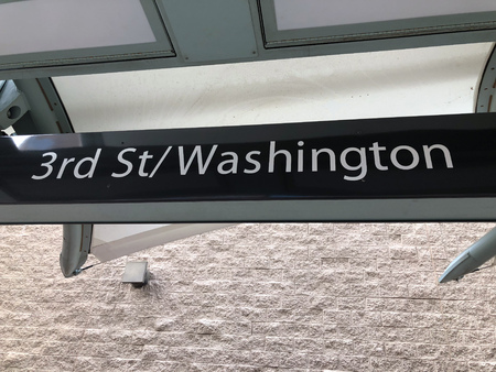 Metro rail train station sign attached to a building wall at 3rd St and Washington in Phoenix...