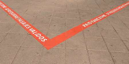 Sign painted on tiles to separate metro station paid fair zone from  pedestrian walkway