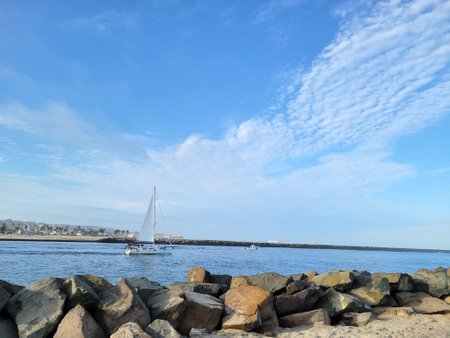 Yacht sailing through Entrance Channel from Mission Bay to Pacific Ocean in San Diego, Californiaの写真素材