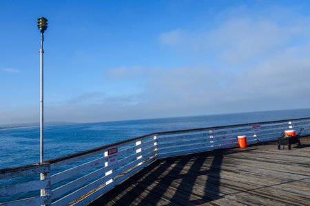 Fishing spinning rods and red canisters in a fishing corner at Crystall Pier in San Diego, Southern Californiaの写真素材