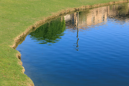 Clean and calm shore side water surface edge of Dos Lagos park lake during early spring, Glendale, Arizonaの写真素材