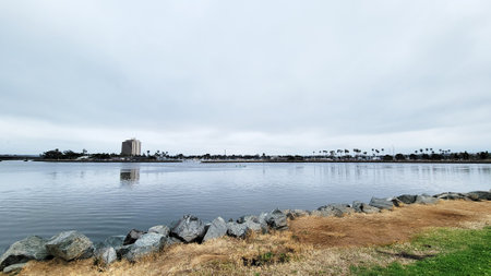Marina and hotels in Quivira Basin as seen across mirror-like water surface of bay entrance channel...
