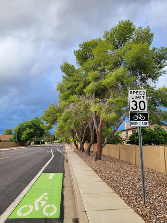 Designated reserved bike lane separated from main road part by a wide white line along residential...