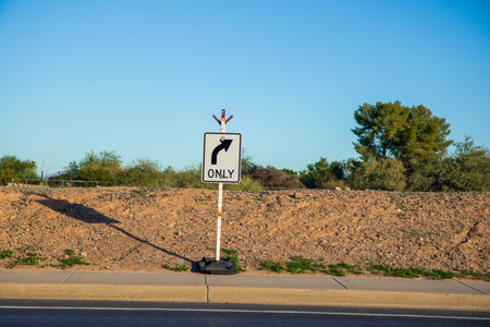 White rectangular shaped Right Only directional road sign set on the edge of a pedestrian concrete...