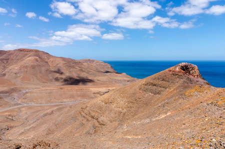 Typical landscape of Fuerteventura with barren volcanic mountains and the ocean - a view from the Entallada lighthouse terraceの写真素材