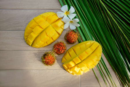 Mango, rambutan and frangipani flower on a palm leaf. Fresh Tropical Fruitsの写真素材