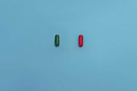 red and green pills isolated on blueの写真素材