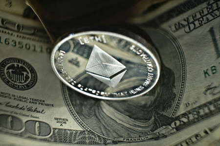 cryptocurrency, ethereum coin laying on dollar banknoteの写真素材