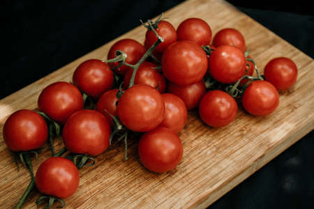 Tomatoes on the vine on rustic wooden backgroundの写真素材