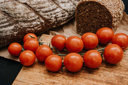 Fresh bread on paper on wooden background