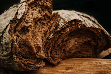Fresh bread on paper on wooden backgroundの写真素材