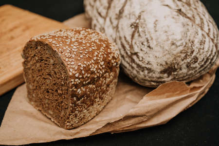 Fresh bread on paper on wooden background