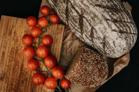 Fresh bread on paper on wooden backgroundの写真素材