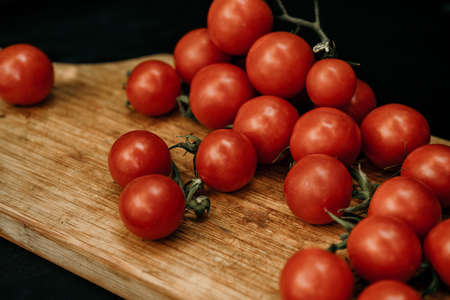 Tomatoes on the vine on rustic wooden backgroundの写真素材