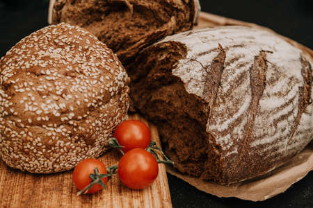 Fresh bread on paper on wooden backgroundの写真素材