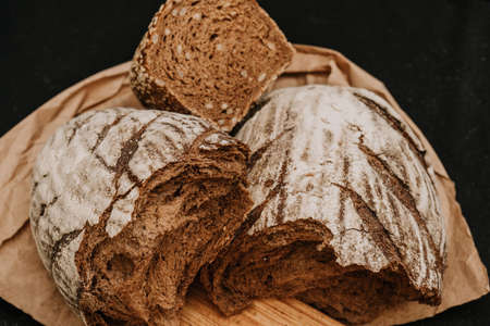 Fresh bread on paper on wooden background