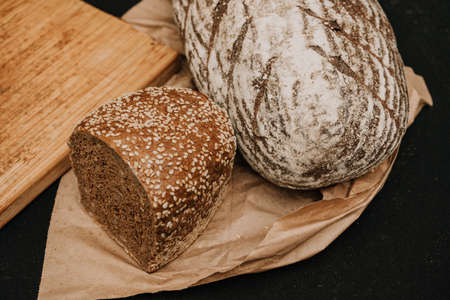 Fresh bread on paper on wooden backgroundの写真素材