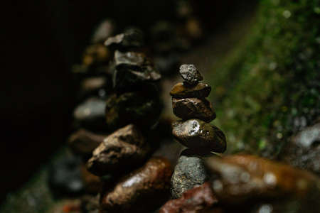 Balancing stones tower on mossy stone backgroundの写真素材